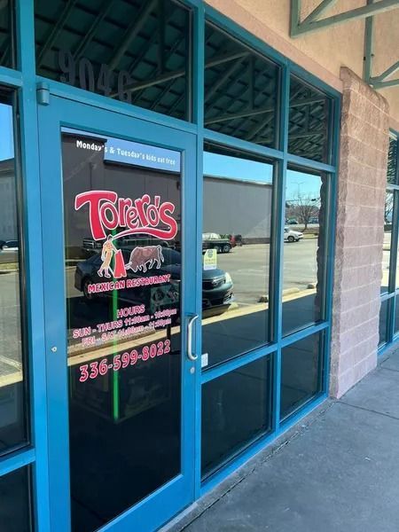 Toredo's Mexican Restaurant storefront with blue door and windows, phone number visible, exterior.