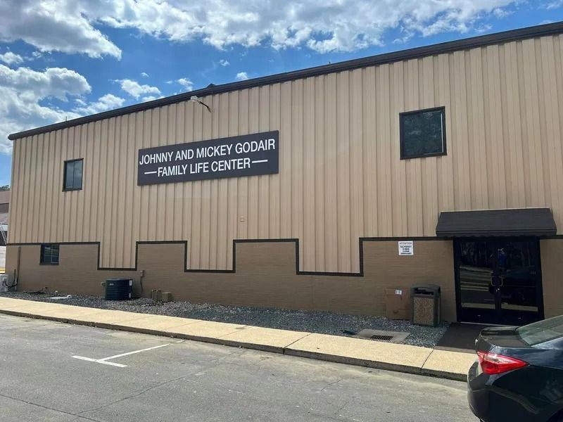 Exterior of the Johnny and Mickey Goodair Family Life Center, a tan-colored building with a sign and small windows.