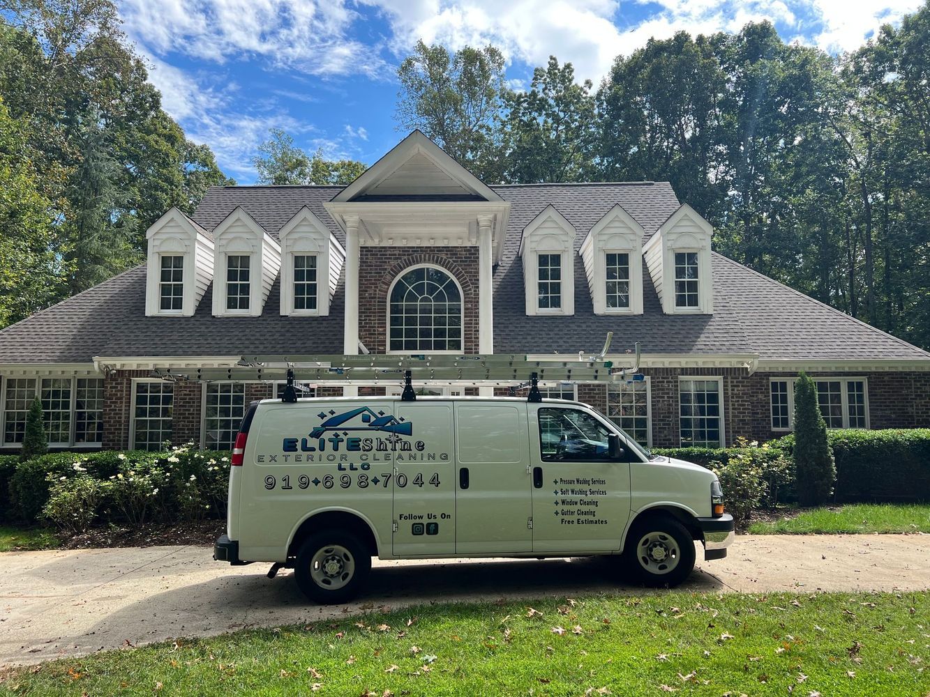White van with ladder parked in front of a house. Roofing company logo on the van.