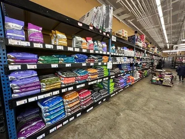 Shelves stocked with various pet food bags in a pet store.