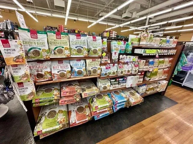 Shelves stocked with various bags of dog food inside a store.