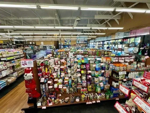 Interior of a pet store with various pet supplies, displays, and products on shelves.