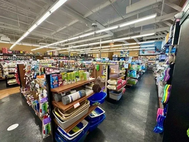 Inside a pet store, shelves stocked with pet supplies and toys.