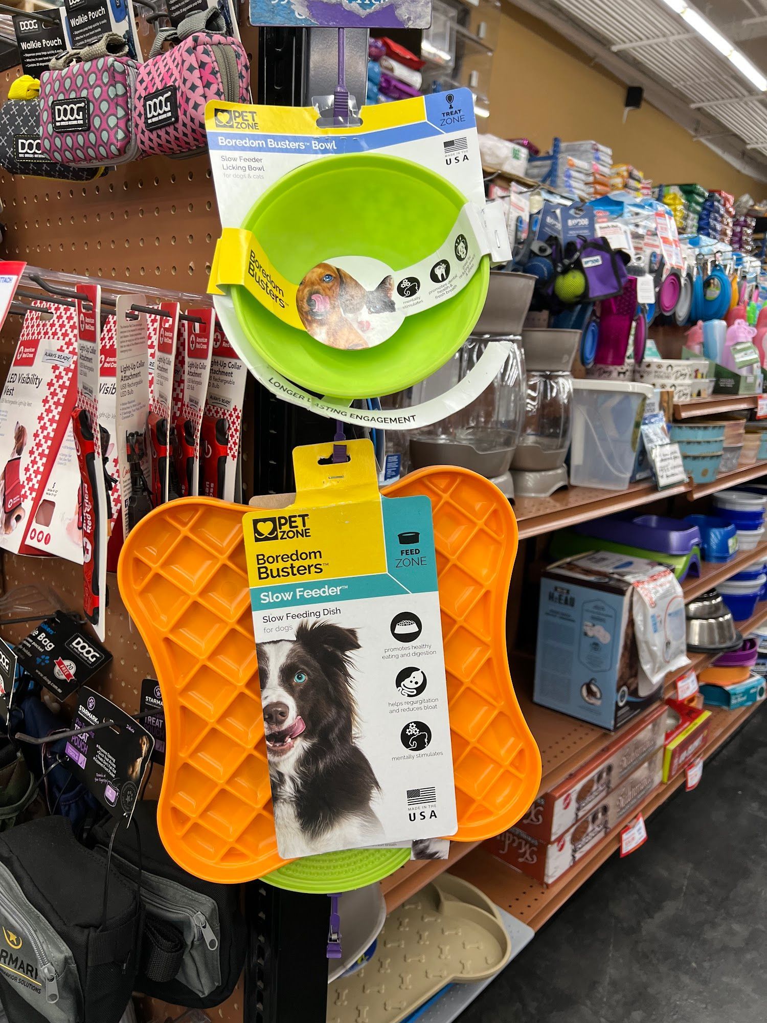 Dog bowls and treat puzzle on display in a pet store.