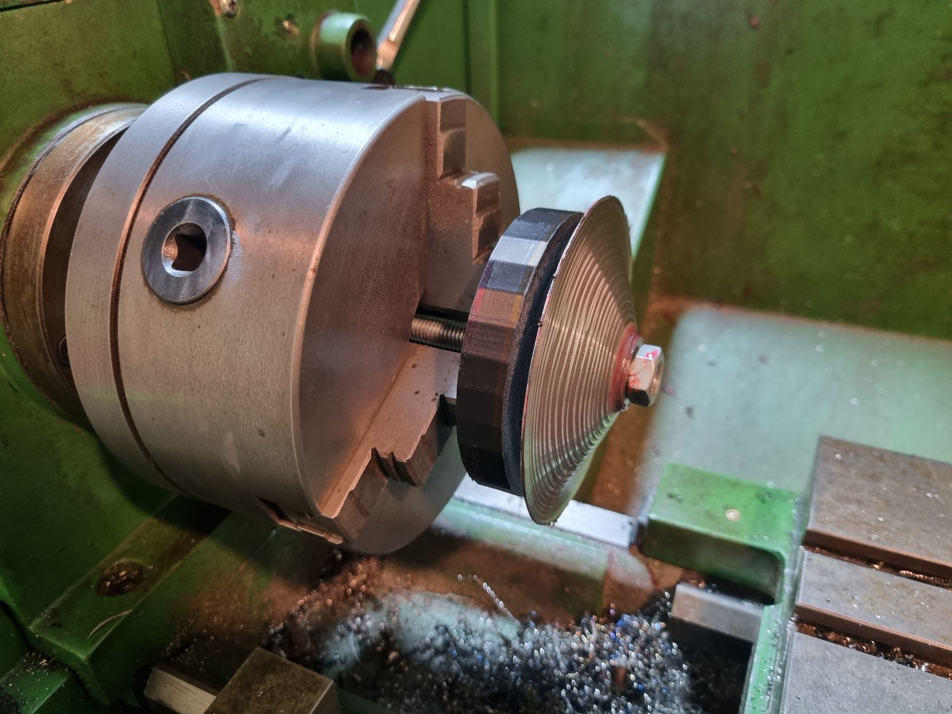 Metal spinning silencer end caps on a lathe.