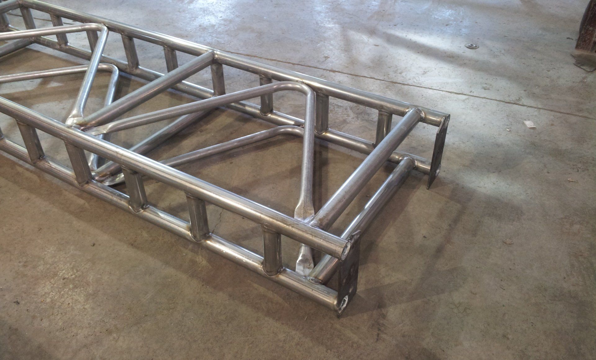 A metal ladder is sitting on top of a concrete floor.