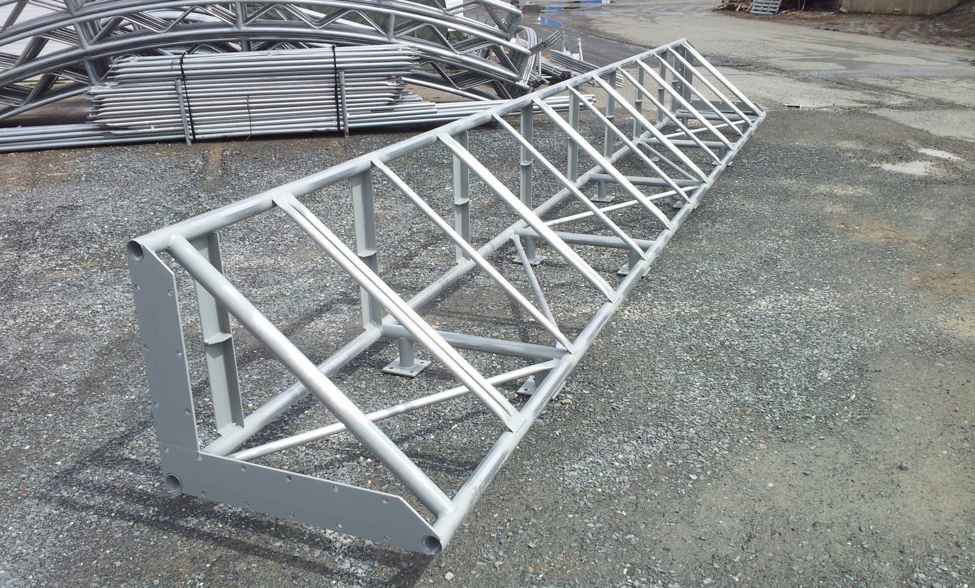 A metal structure is sitting on top of a gravel road.
