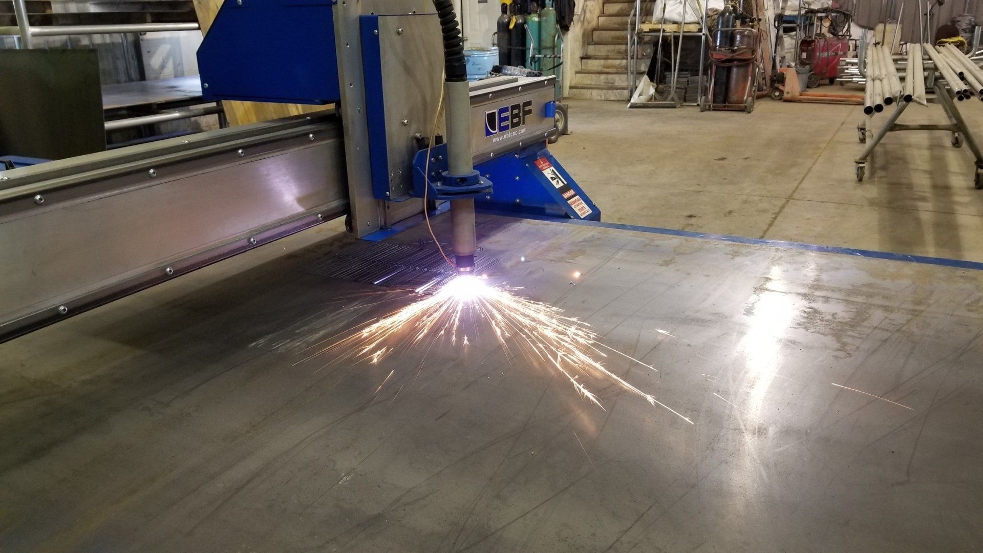 A machine is cutting a piece of metal in a factory.