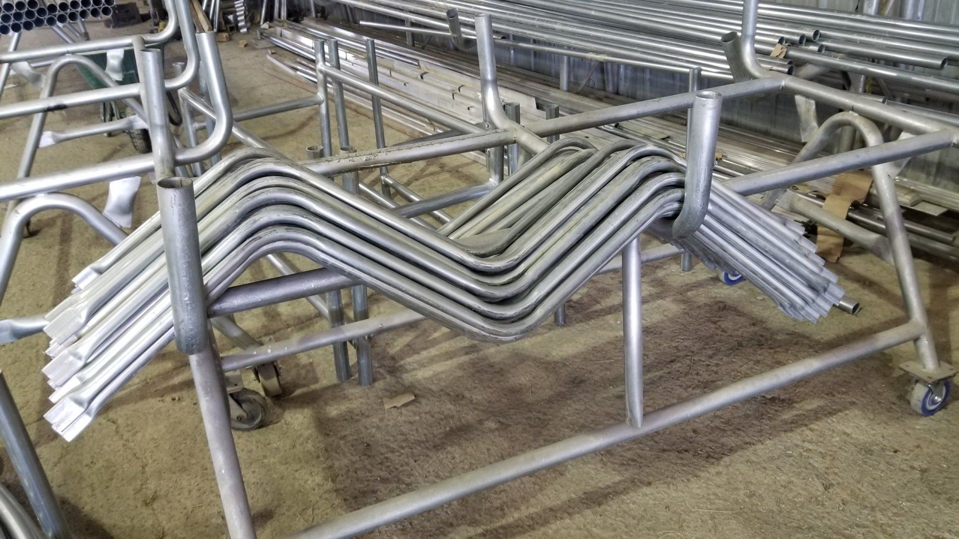 A bunch of metal pipes are stacked on top of each other on a cart.