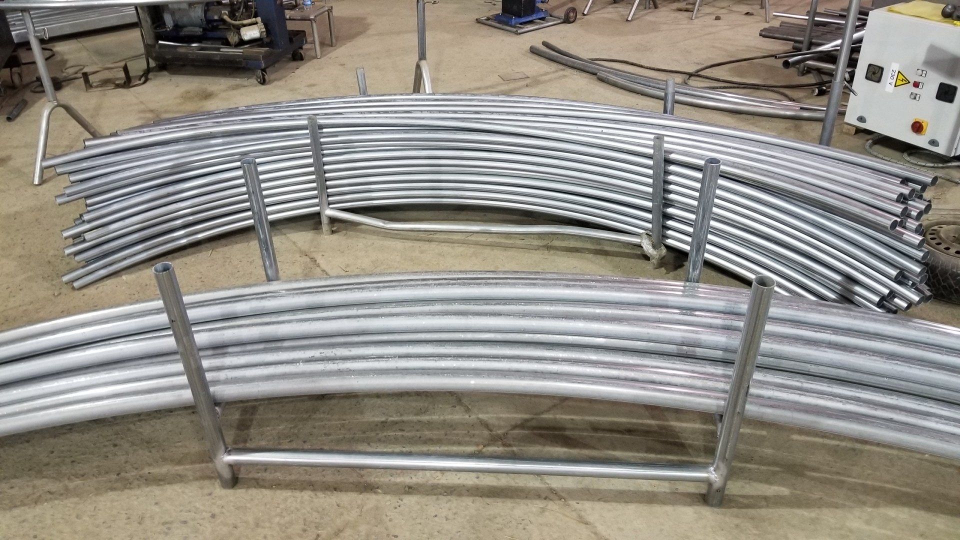 A bunch of metal pipes are stacked on top of each other on a rack.