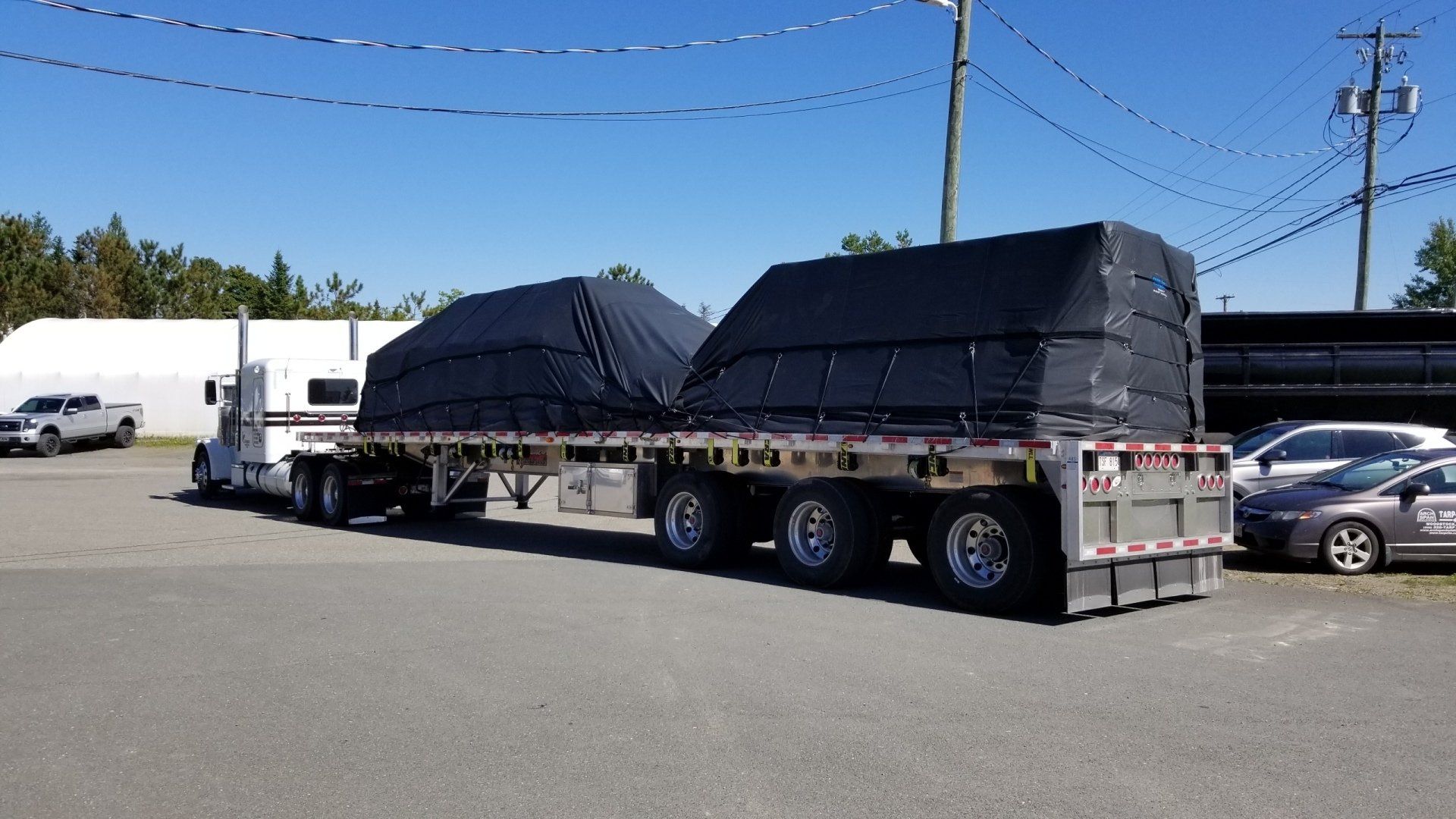 A semi truck is carrying a large load on a flatbed trailer.