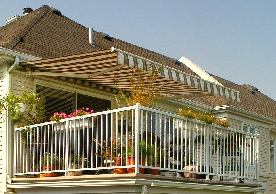 A house with a balcony with a canopy over it