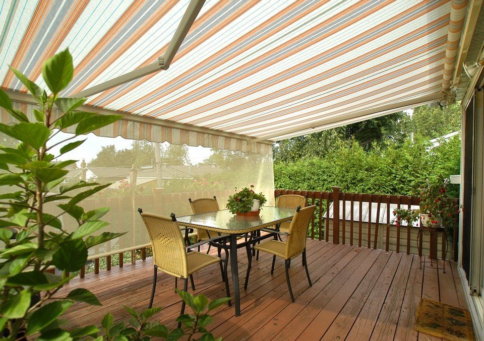 A patio with a table and chairs under an awning.