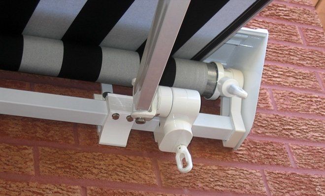 A black and white striped awning is attached to a brick wall