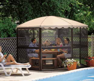 A group of people are sitting under a screened in gazebo near a pool