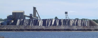 A large building is sitting next to a body of water.