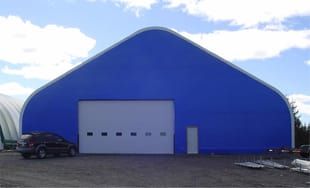 A blue building with a car parked in front of it