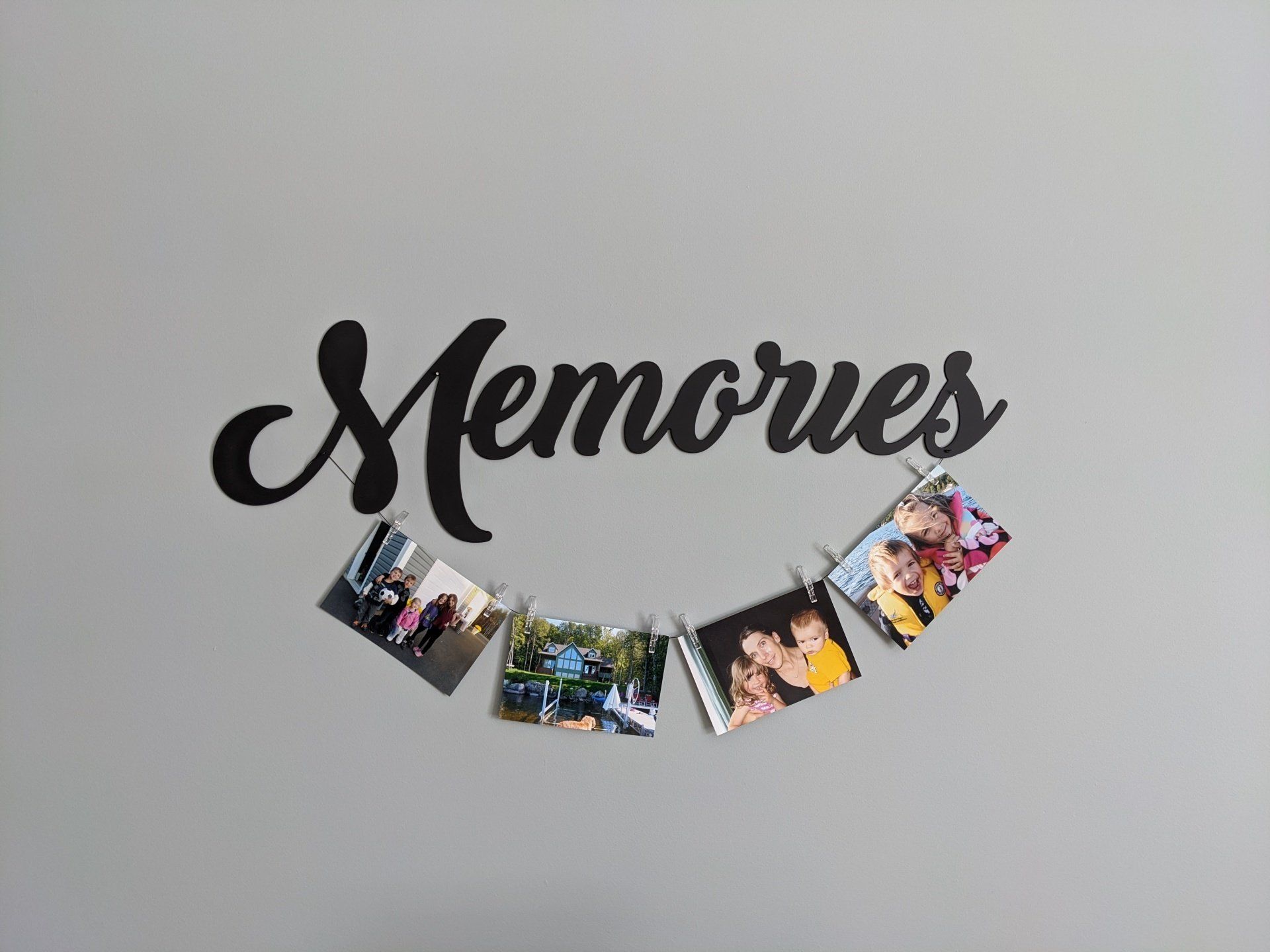 A bunch of pictures are hanging on a wall under the word memories.
