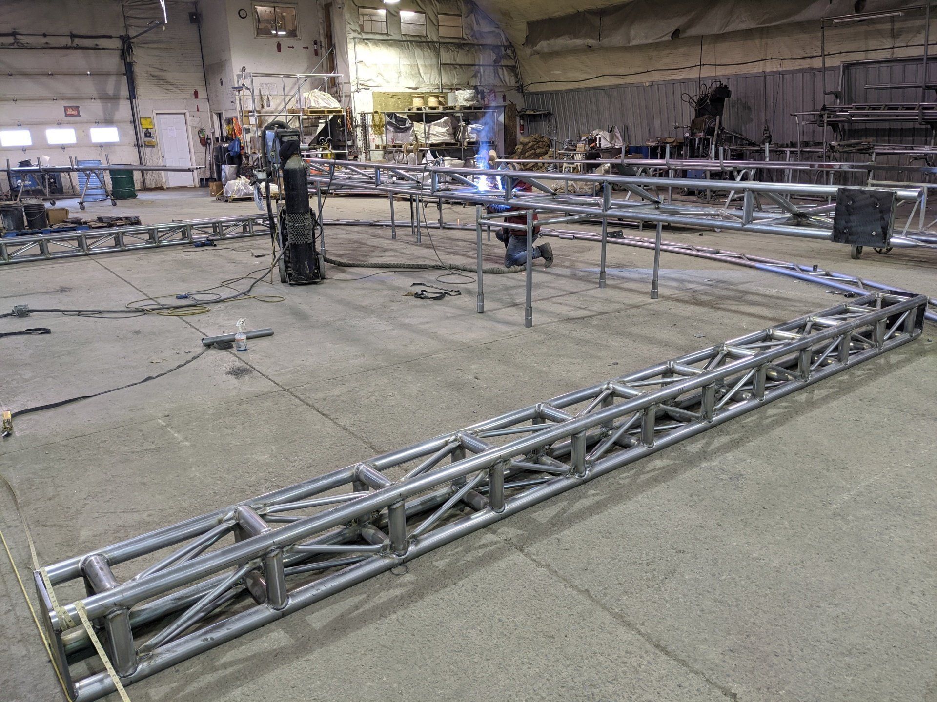 A large metal structure is being built in a factory.