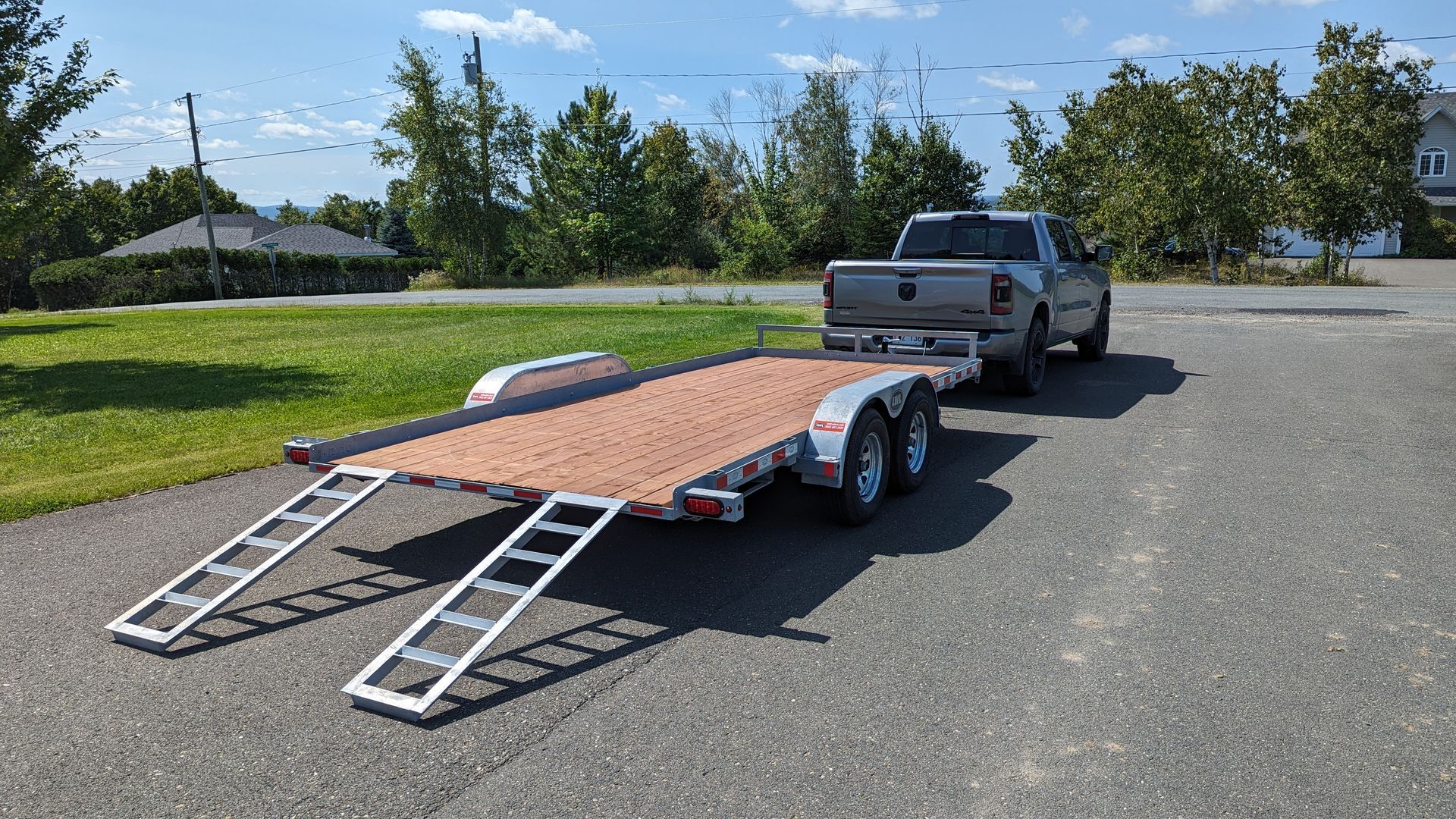 A truck is towing a trailer down a road.