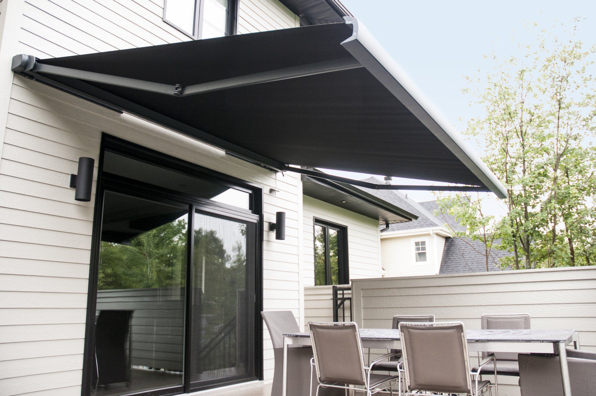 A patio with a table and chairs under an awning