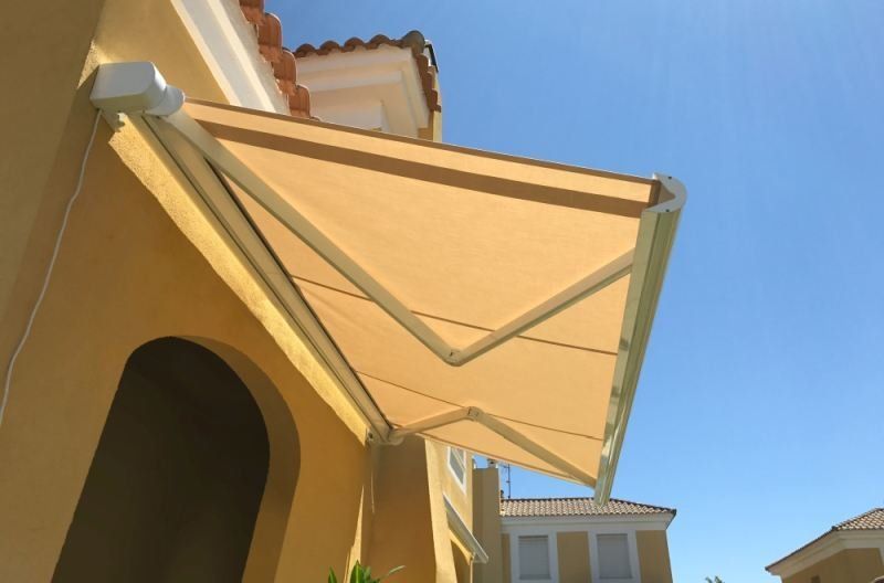 A yellow building with a white awning on it