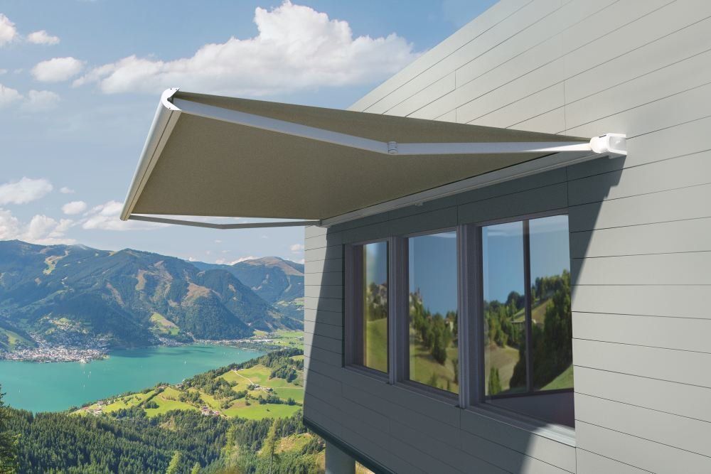 A balcony with a canopy overlooking a lake and mountains