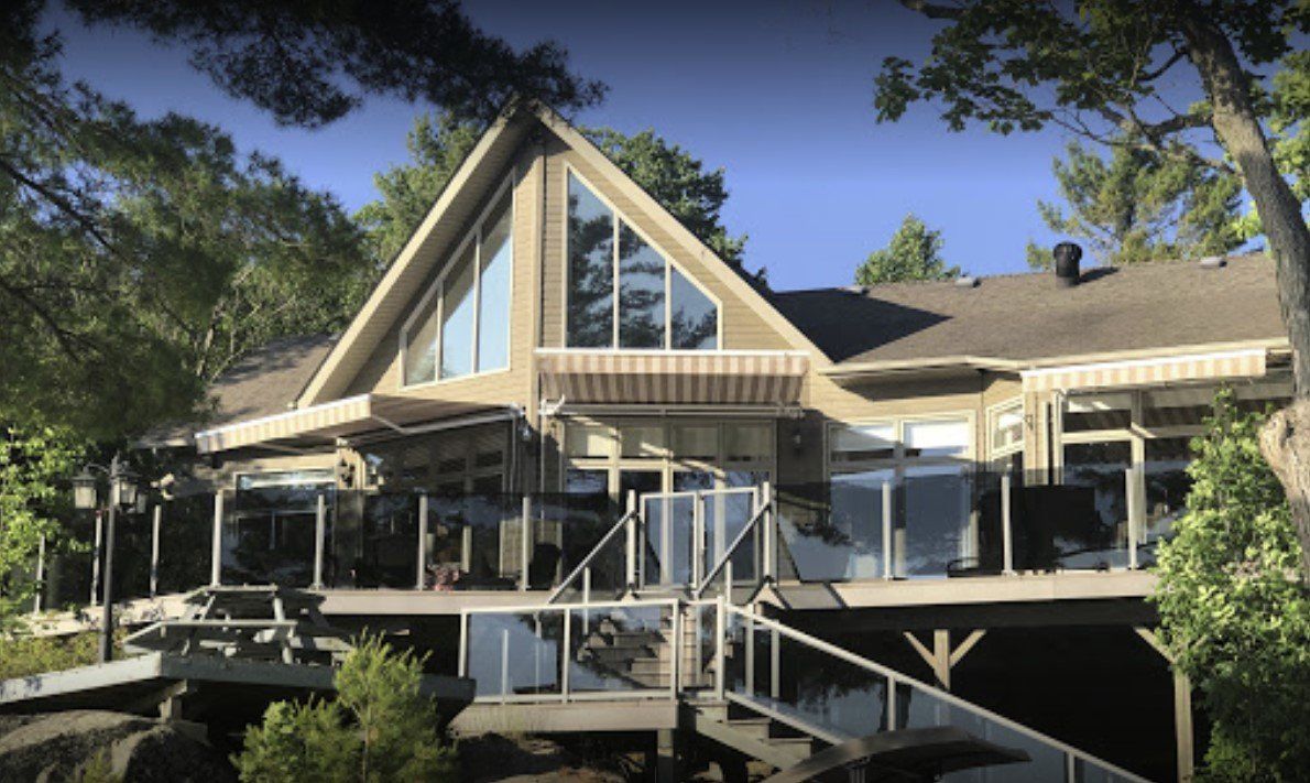 A large house with a lot of windows is surrounded by trees.