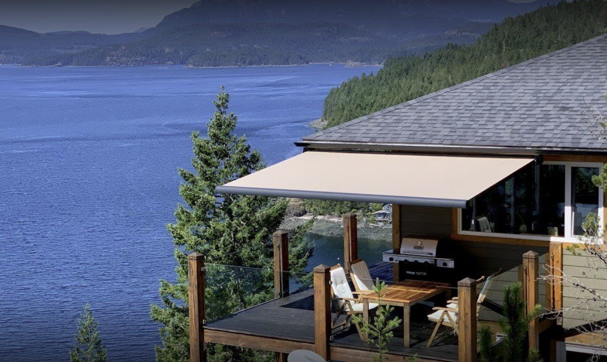 A house with a large deck overlooking a lake.