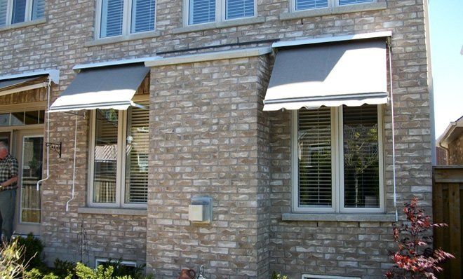A brick house with a awning on the windows