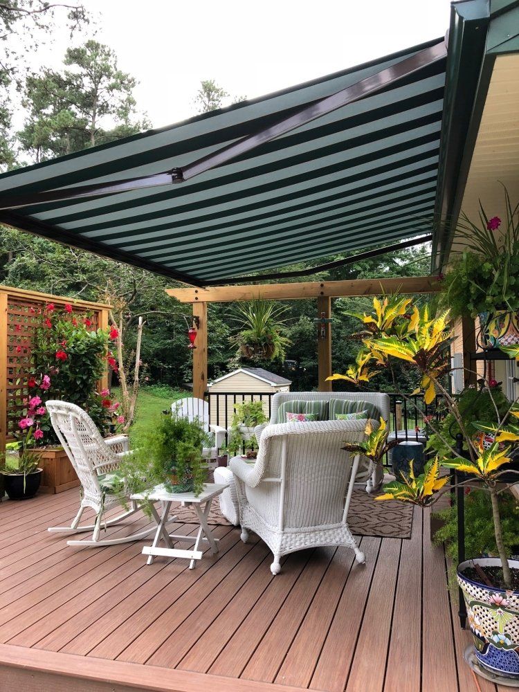 A deck with a canopy over it and a table and chairs on it.