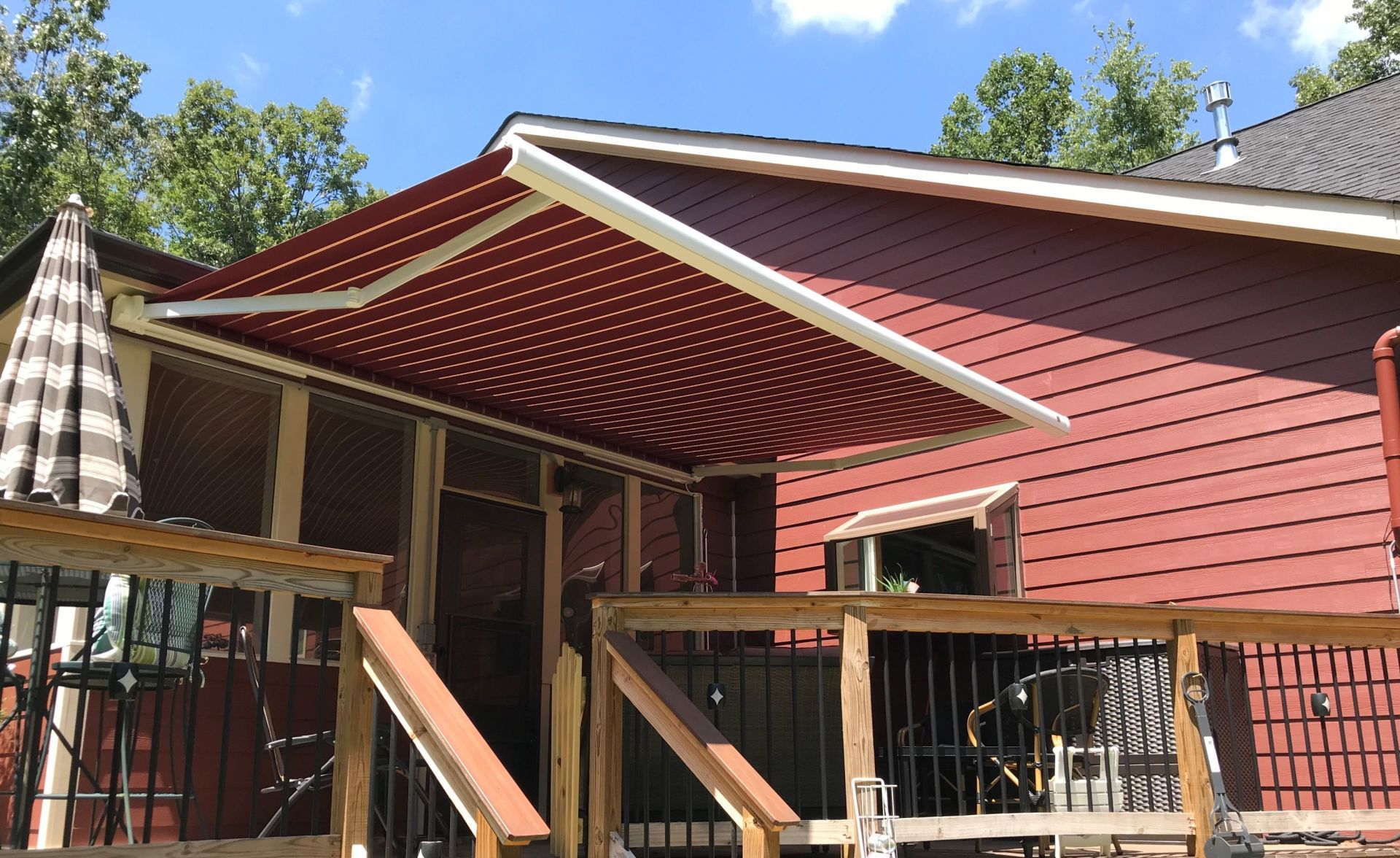 A red house with a red awning on the side of it