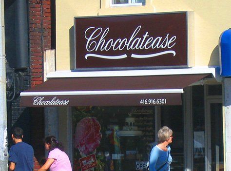 People walking in front of a store called chocolatease