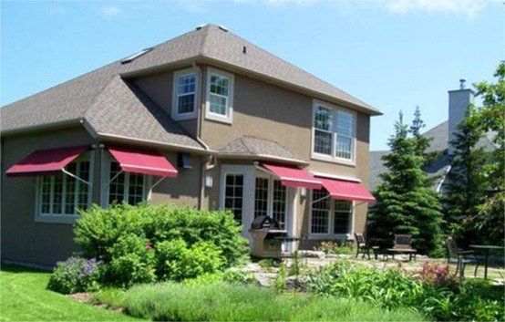 A large house with red awnings on the windows