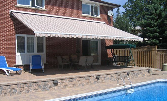 A house with an awning over a swimming pool