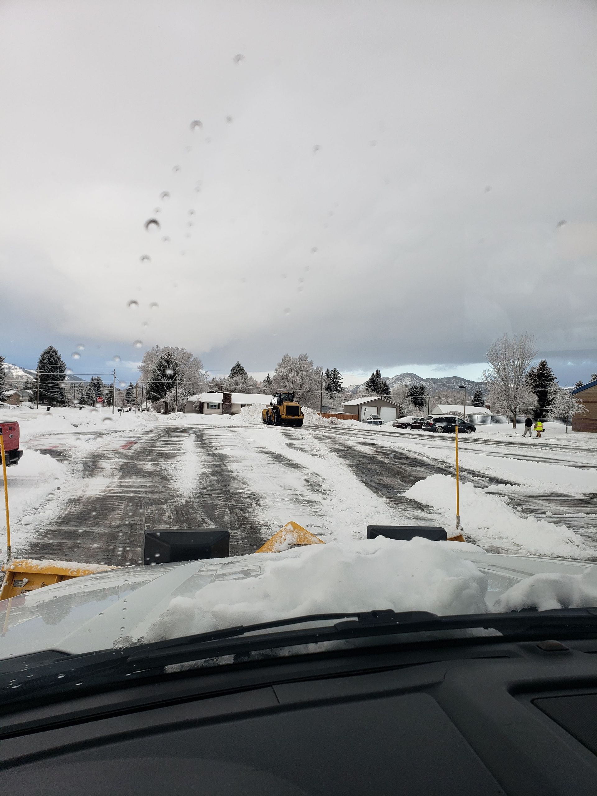 A Car Is Driving Down a Snow Covered Road.