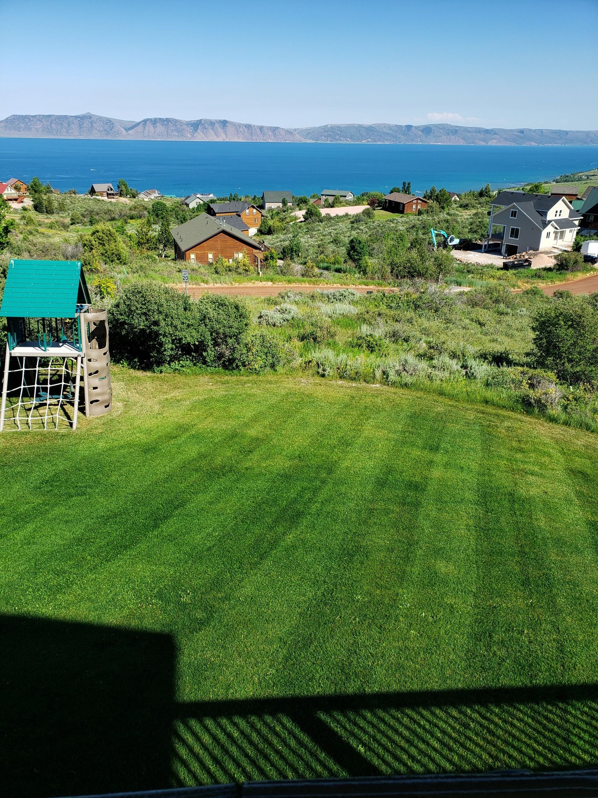 A View of The Ocean from A Balcony Overlooking a Lush Green Field.