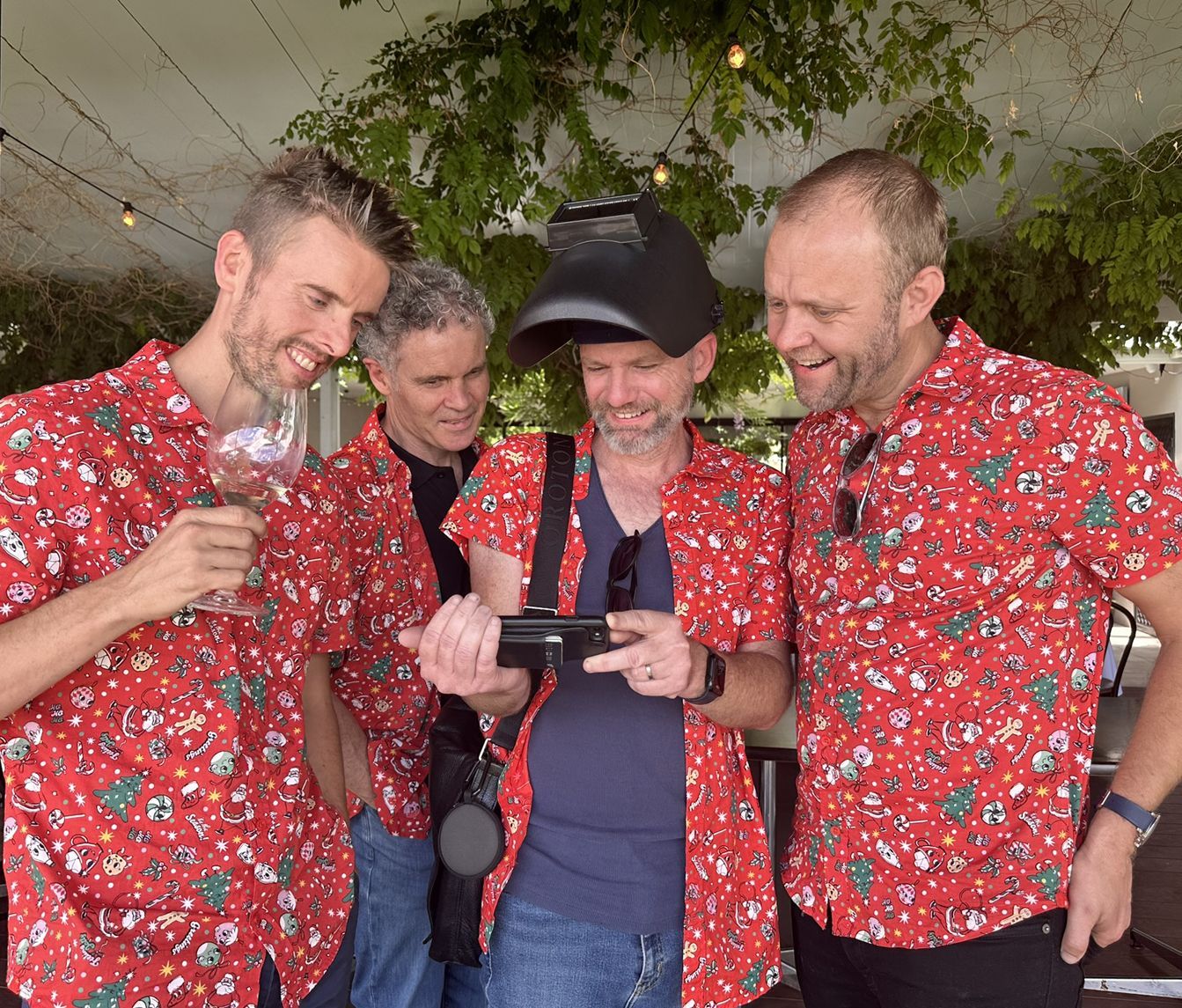 A group of men wearing red shirts are standing next to each other.