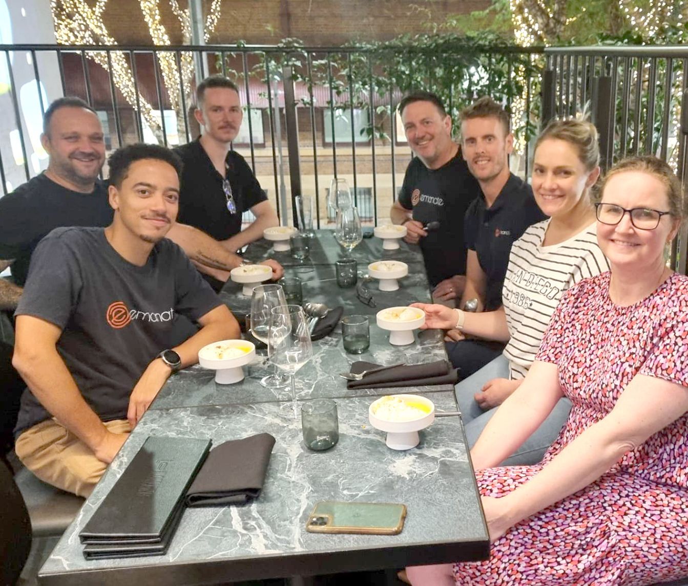 A group of people are sitting around a table with bowls of food.