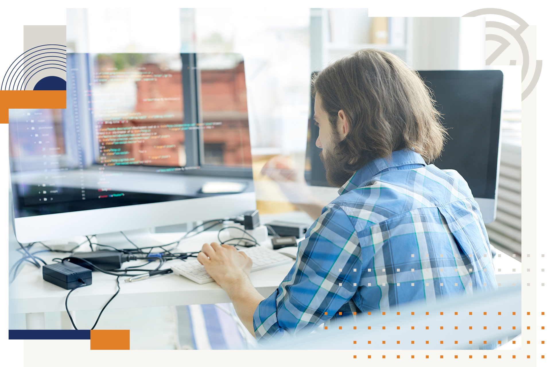 A man is sitting at a desk in front of a computer.