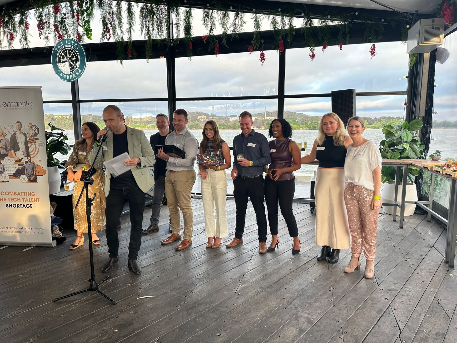 A group of people are standing in front of a microphone.