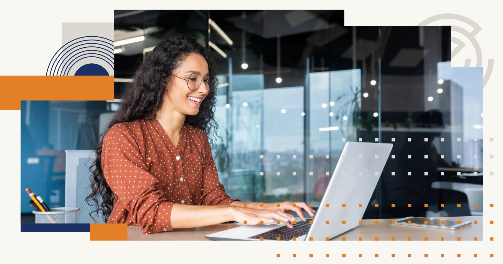 A woman is sitting at a desk typing on a laptop computer.