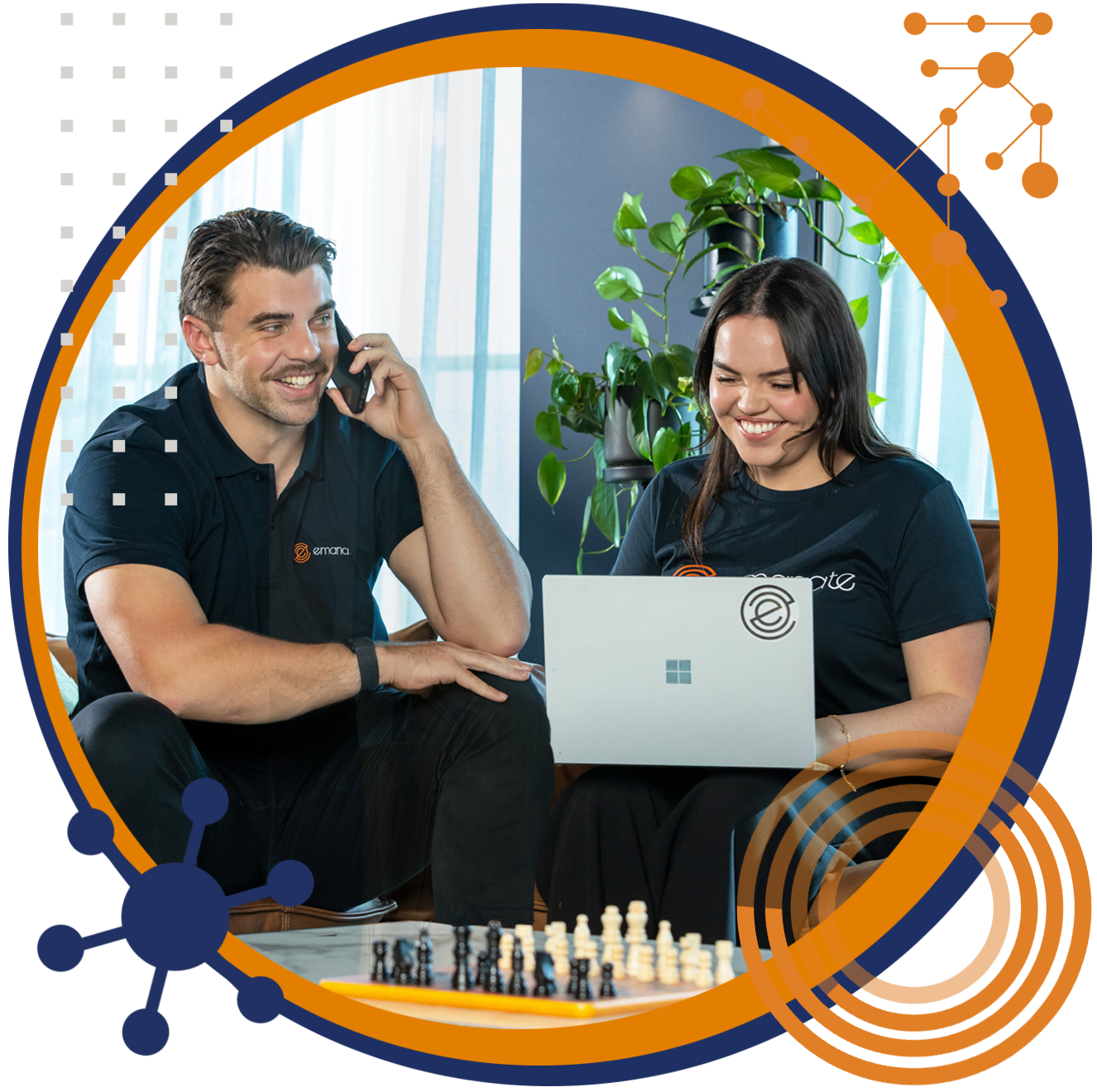 Man on phone and woman using a laptop smiling, sitting by a chessboard. Inside an orange circle graphic.