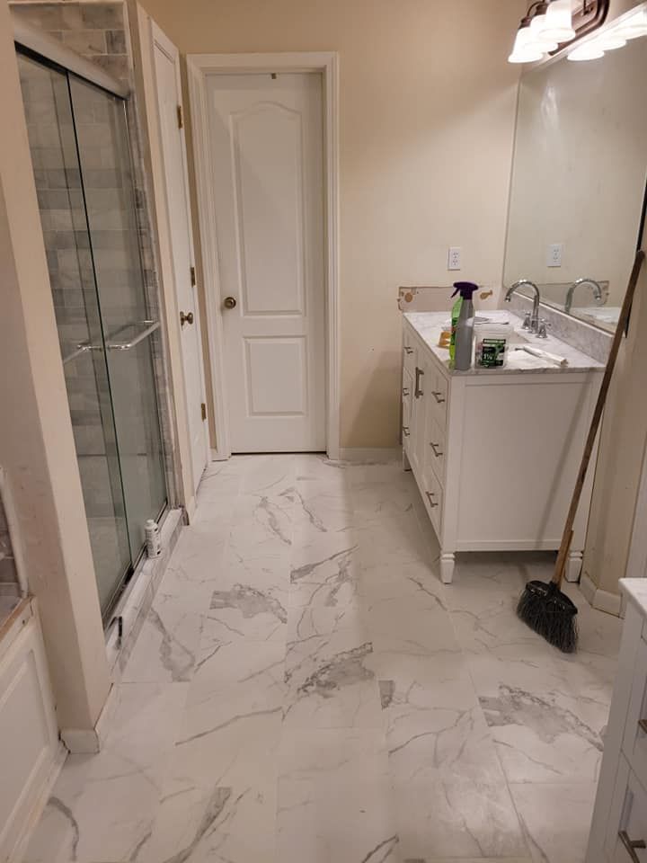 A bathroom with a sink , mirror , and shower.