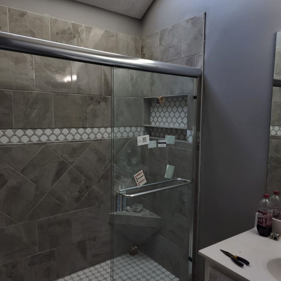 A bathroom with a sliding glass shower door
