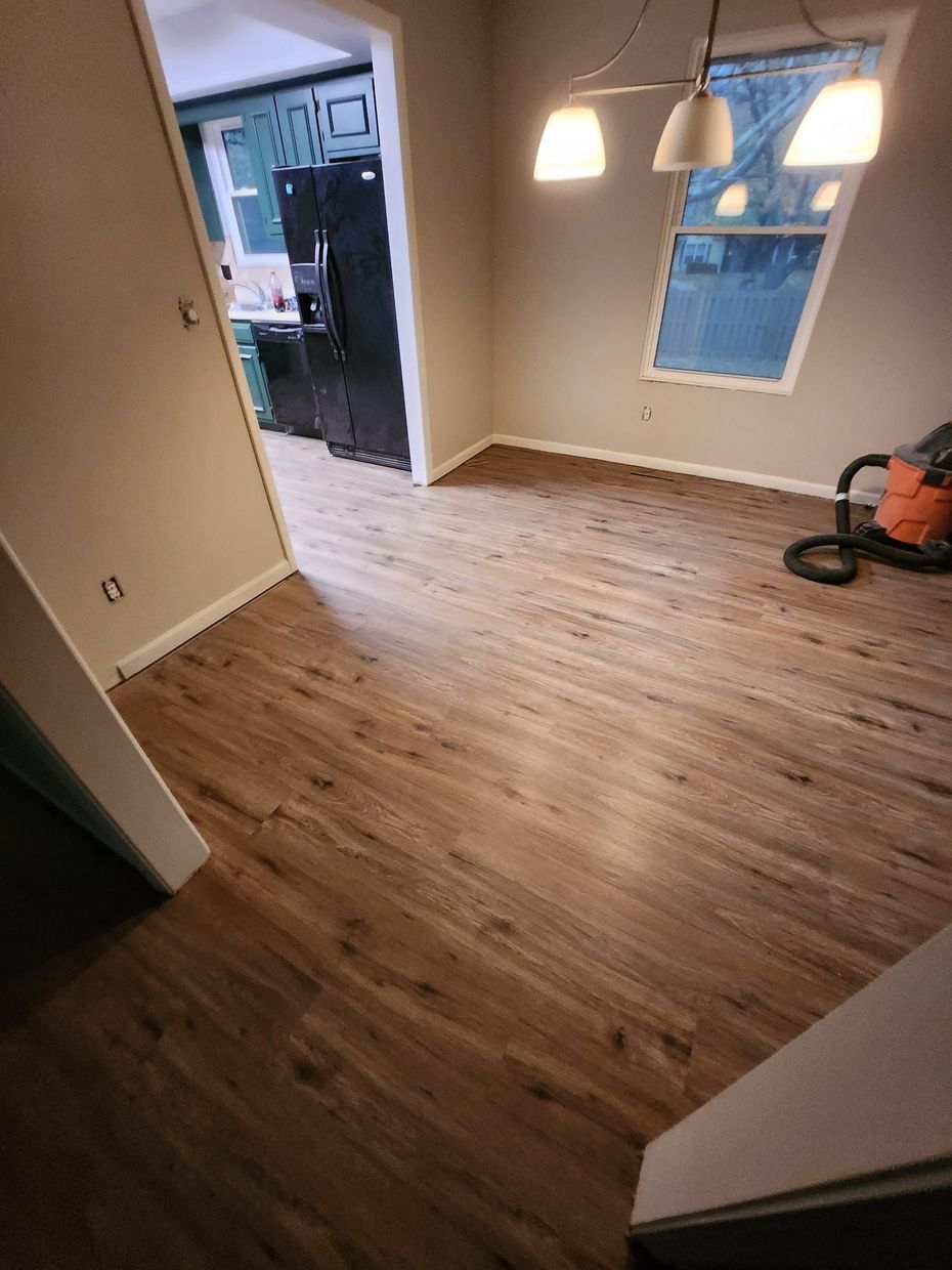 A room with hardwood floors and a vacuum cleaner in it.