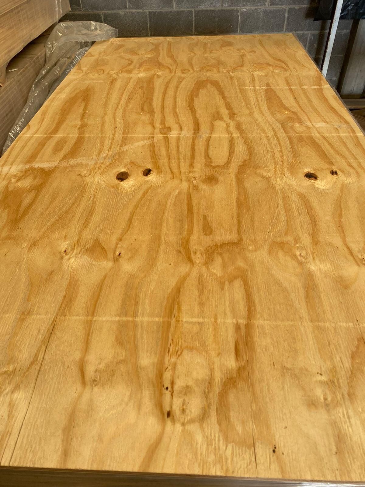 Un trozo de madera contrachapada está encima de una mesa de madera.