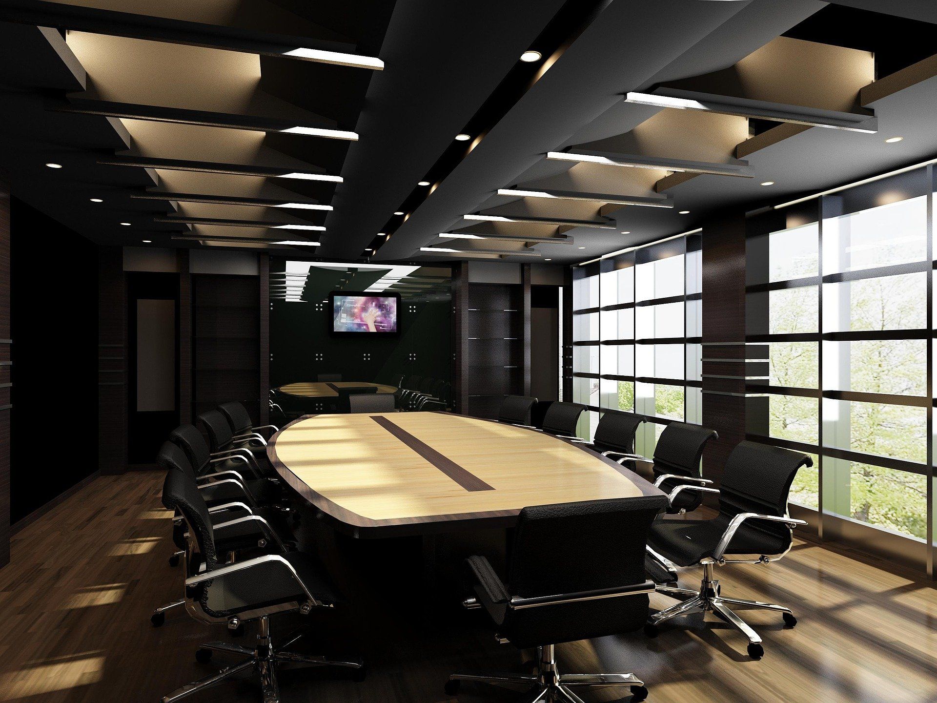 Modern conference room with long oval table, black chairs, and large windows.