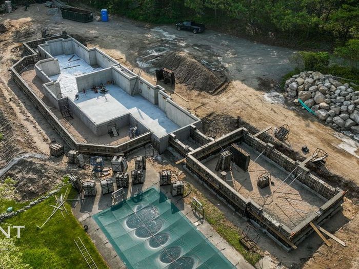 An aerial view of a house under construction with a pool