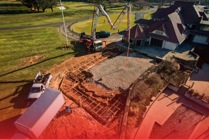 An aerial view of a house being built with a concrete pump.